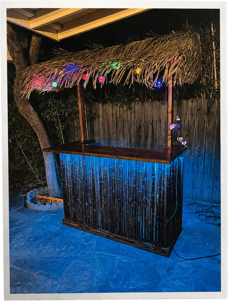 A small bamboo tiki bar with a thatched roof.